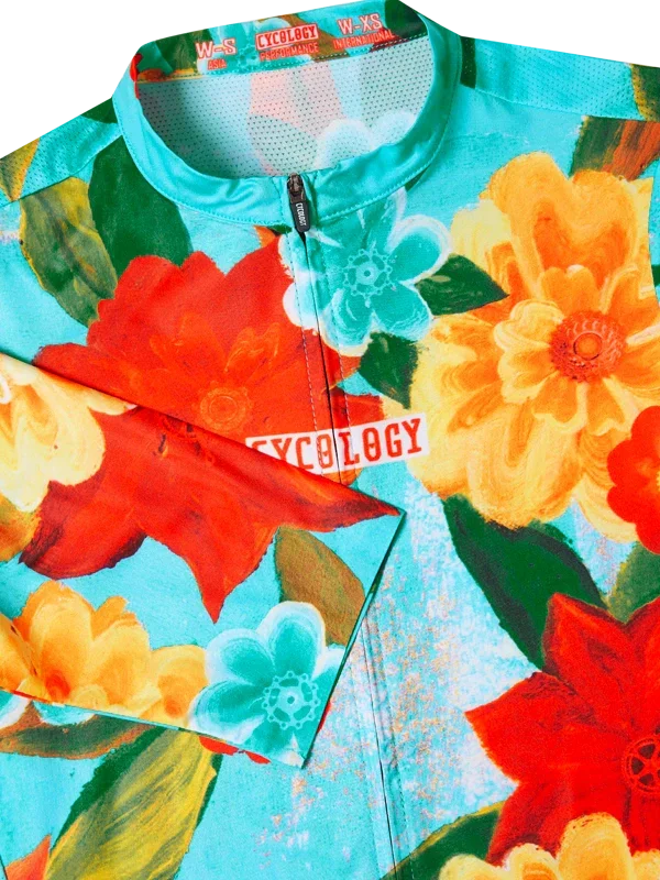 Colorful floral-patterned cycling jersey with 'Cycology' branding on a aqua background