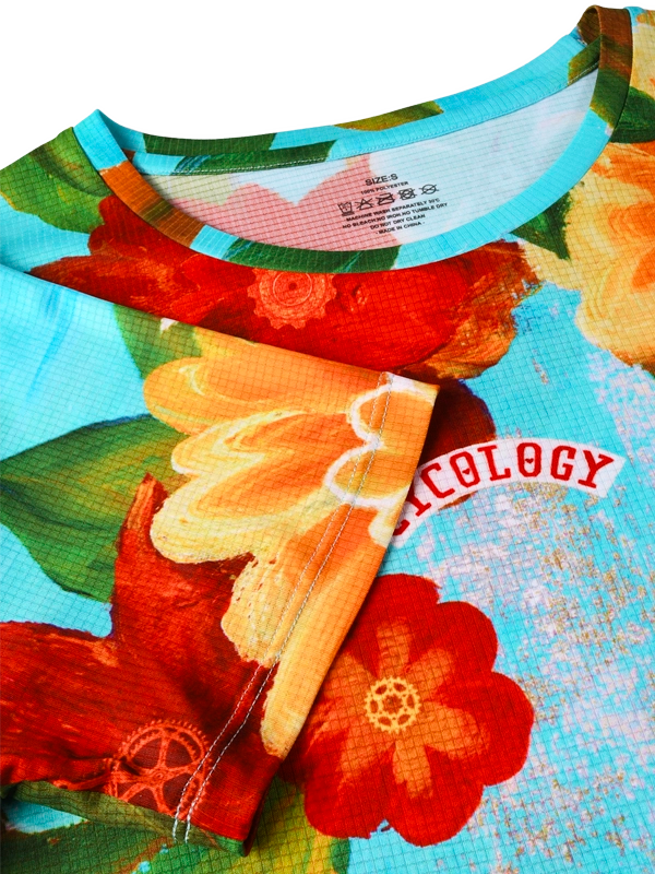 Neck on Women's colorful floral  technical t-shirt with red, yellow, and orange flowers on a aqua blue background