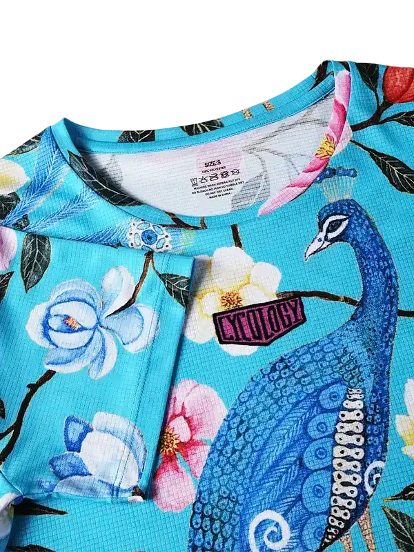 Blue peacock floral cycling jersey with vibrant print and brand patch