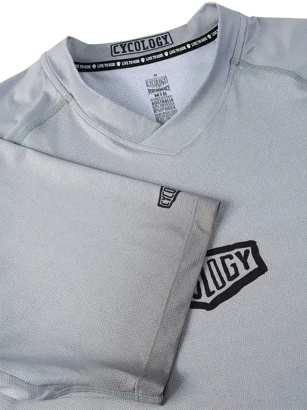 Grey cycling jersey with 'Cycology' logo, breathable fabric, V-neck design for men and women