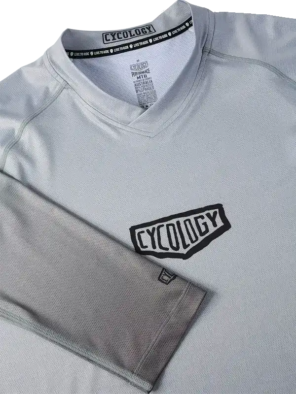 Grey cycling jersey with black Cycology logo, breathable fabric, V-neck design for men and women