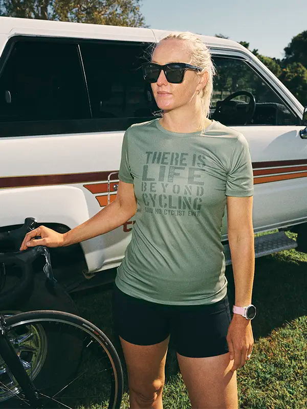 Woman wearing a t-shirt with text standing next to a vehicle