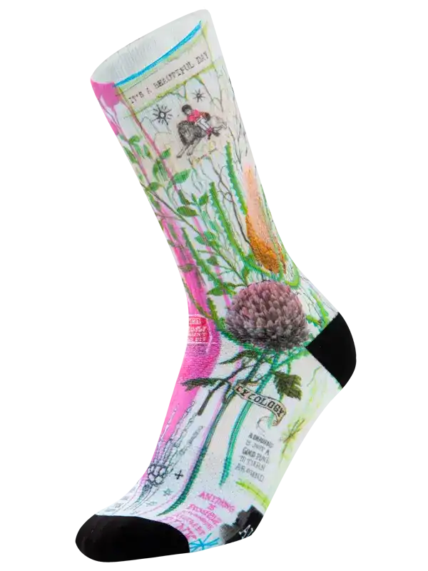 A single crew cycling sock with a detailed botanical and vintage-style illustration print, featuring a pink thistle, green leaves, and text elements on a white base, with black toe and heel sections.