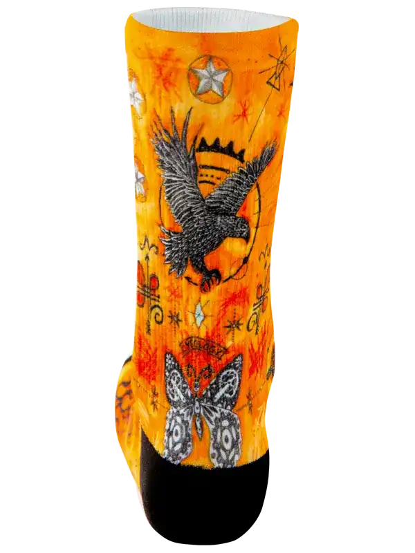 A single crew cycling sock with a vibrant orange and yellow background featuring a detailed  art pattern of snakes, stars, and geometric symbols, finished with solid black toes and heels.