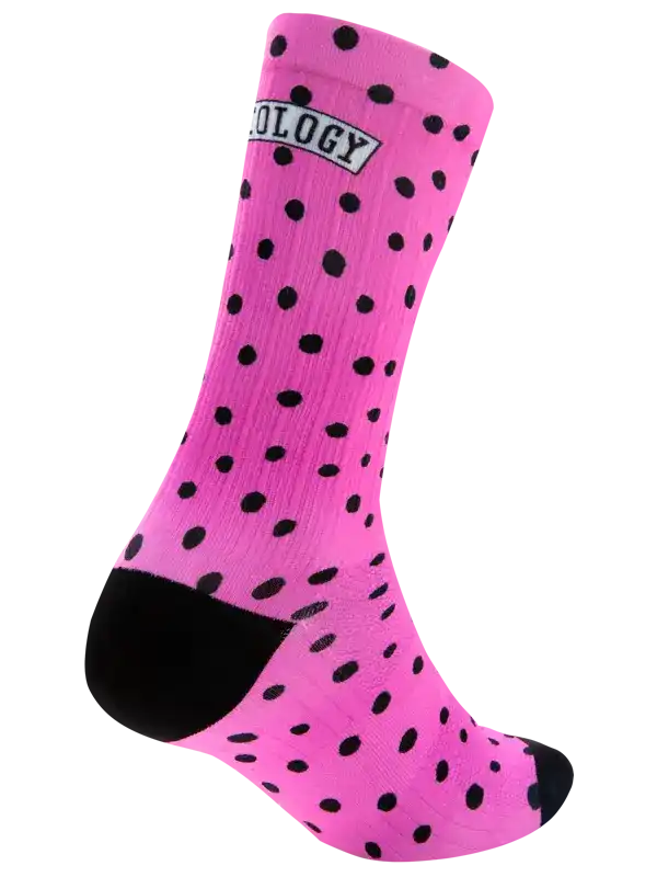 A single bright pink crew sock with black polka dots, a black heel, and a black toe, featuring a white and black 'CYCOLOGY' logo patch near the cuff, shown on a plain white background.