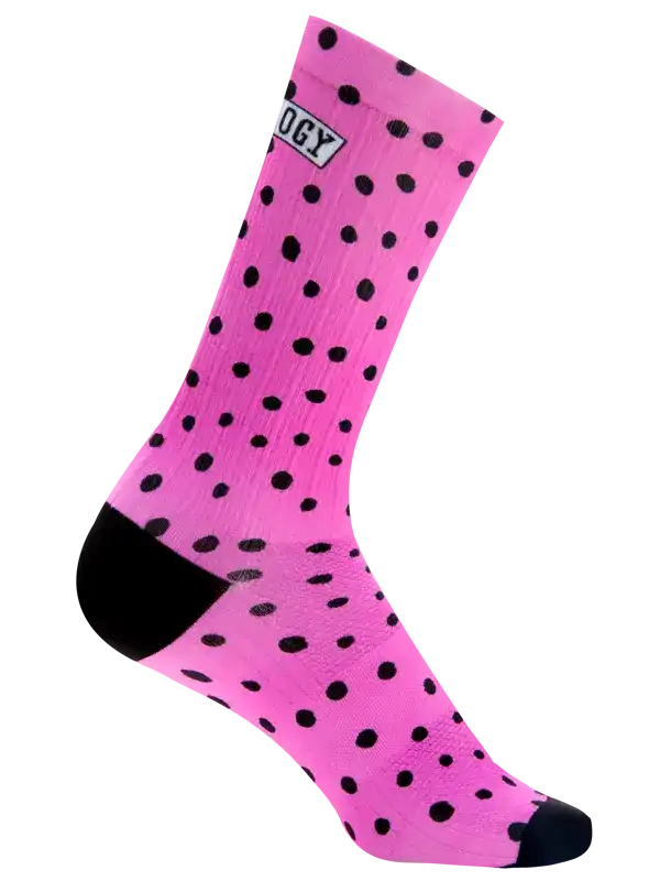 A single bright pink crew cycling sock with black polka dots, a black heel, and a black toe, featuring a small white brand patch near the cuff.