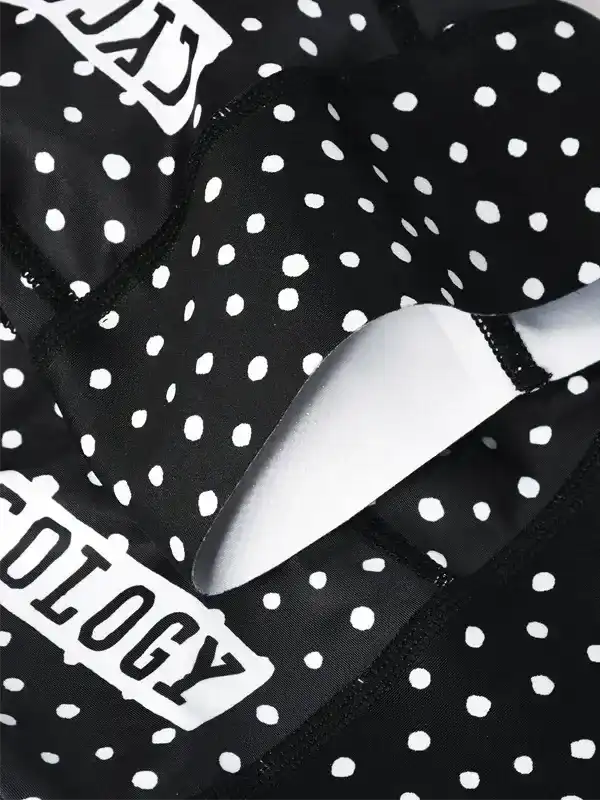 Black and white polka dot cycling shorts with padded chamois, featuring bold 'CYCOLOGY' branding