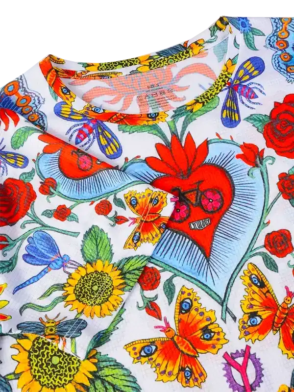 Colorful cycling jersey with floral and butterfly print, featuring sunflowers, roses, and dragonflies on white fabric