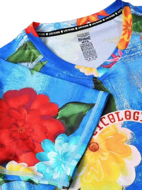 Vibrant floral cycling jersey with bold red, yellow, and blue flowers on performance fabric