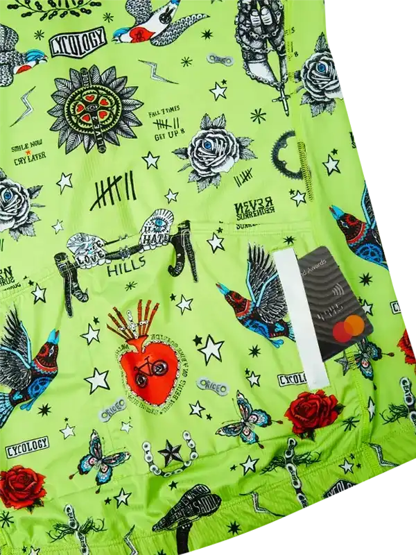 Vibrant green cycling shorts with tattoo-style graphics, roses, birds, and stars for men's or women's bike rides.