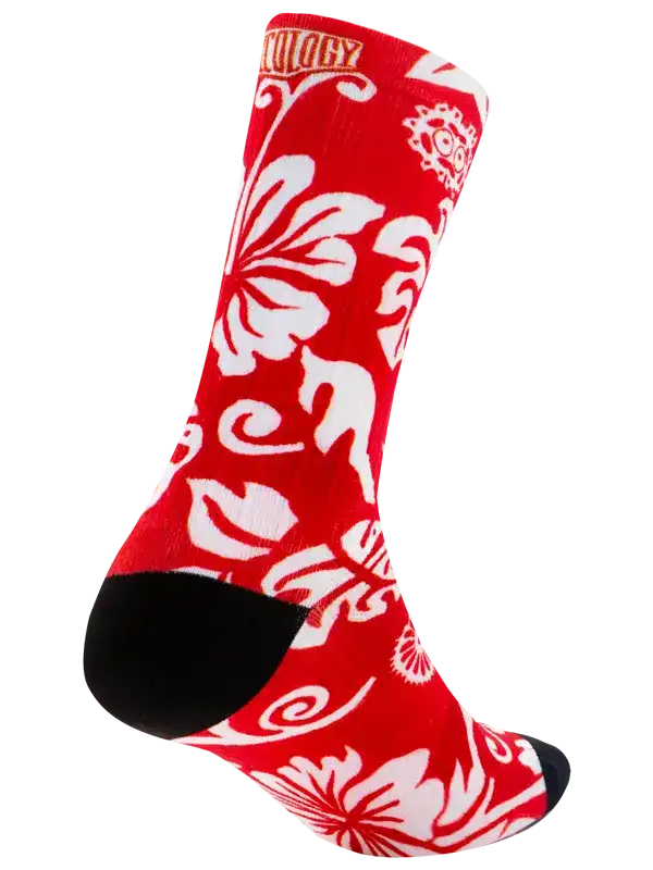 A single crew cycling sock with a vibrant red background and a white floral and scroll pattern, featuring solid black heels, toes, and cuffs, shown against a plain white background.