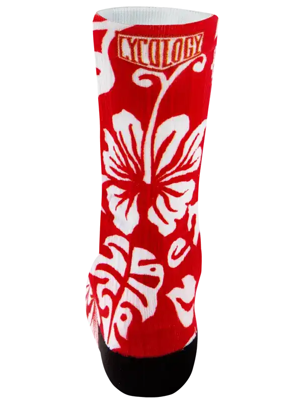 A red crew cycling sock with a white hibiscus flower and monstera leaf pattern, featuring the brand name 'CYCOLOGY' in a white box near the top and a black toe cap, shown on a plain white background.