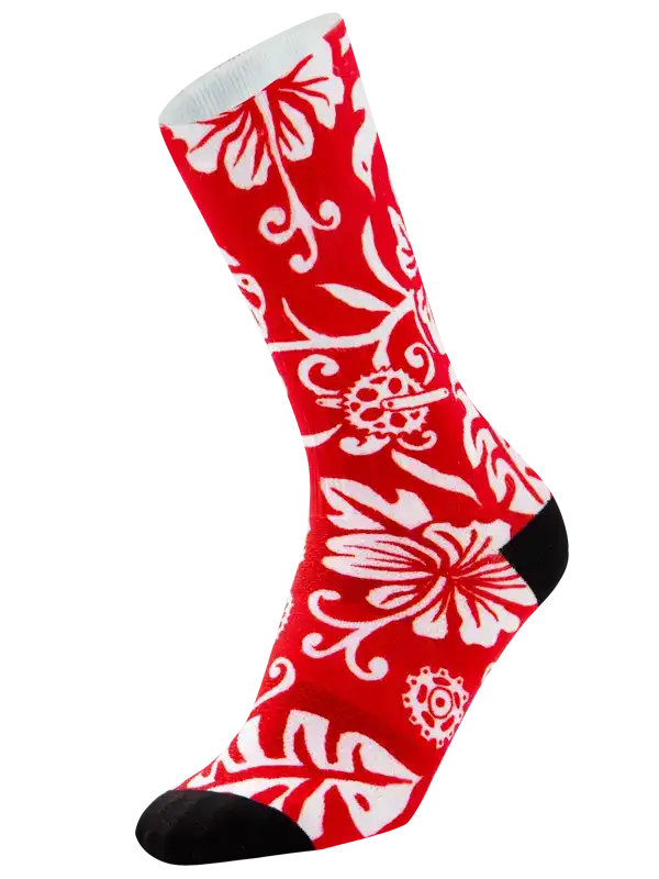 A single crew cycling sock with a vibrant red background and a white floral and scroll pattern, featuring solid black heels, toes, and cuffs, shown against a plain white background.