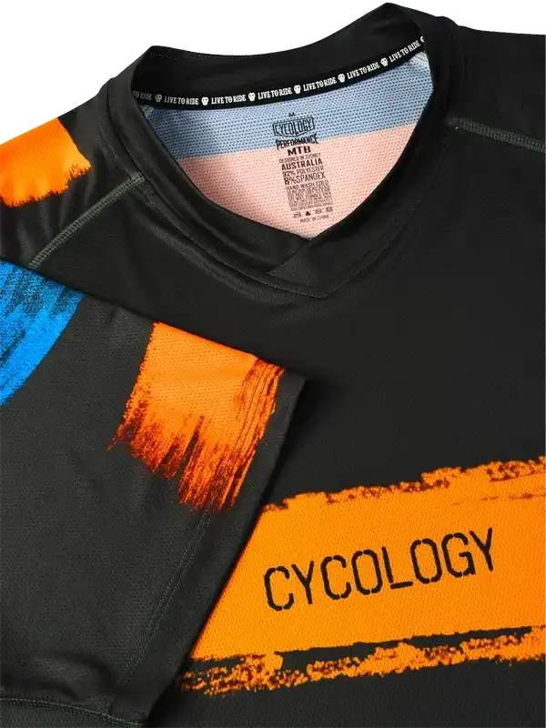 Black cycling jersey with bold orange and blue graphic design, featuring 'CYCOLOGY' text and performance fabric details.