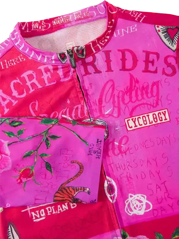 Pink women's cycling jersey with 'Sacred Rides' print, rose and tiger graphics, and Cycology branding
