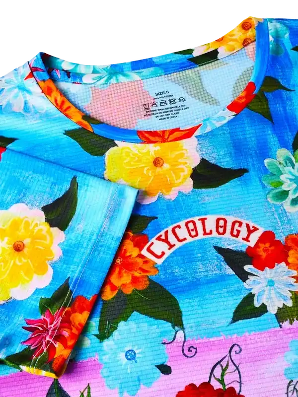 Cycology floral cycling jersey with vibrant flowers and bold logo, perfect for women's bike rides