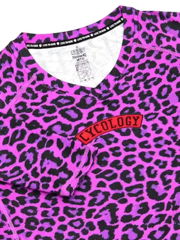 Vibrant pink leopard print cycling jersey with red 'CYCOLOGY' chest patch and 'LIVE TO RIDE' neck tape