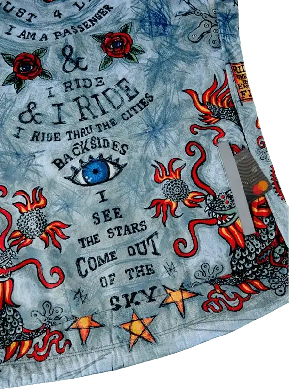 Men's cycling jersey with bold tattoo-style graphics, red roses, dragons, stars, and cycling quotes on light blue fabric