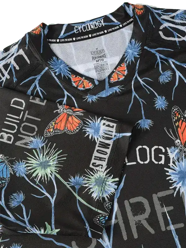 Black cycling jersey with butterfly and thistle print, breathable fabric, V-neck design