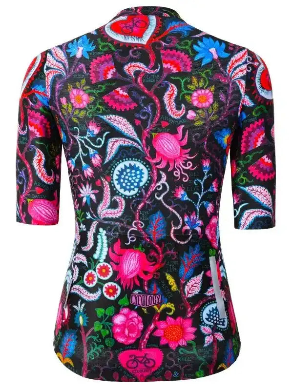 Women's cycling jersey with vibrant floral and paisley print, featuring bold pink, blue, and red patterns on black fabric.