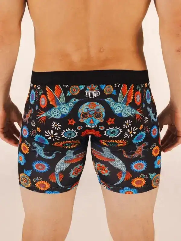 Men's cycling shorts with vibrant hummingbird and sugar skull print, colorful floral patterns on black fabric