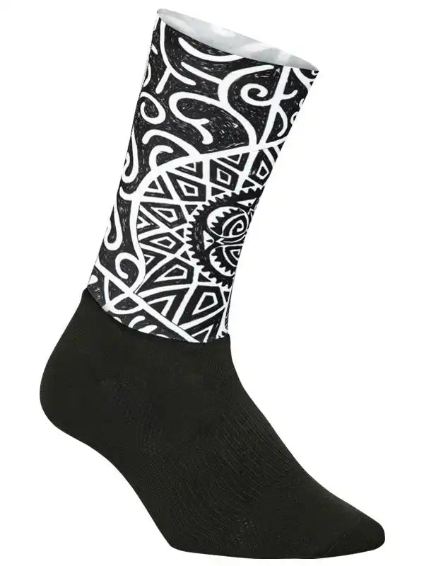 Black cycling sock with bold white tribal and geometric patterns, designed for comfort and style on rides.