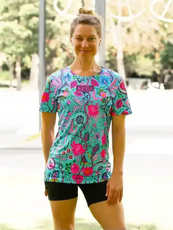 Woman wearing colorful floral cycling jersey and black shorts outdoors
