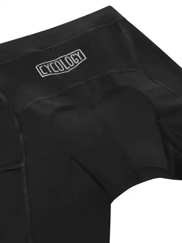 Black cycling shorts with padded seat and CYCOLOGY logo, designed for comfort and performance.