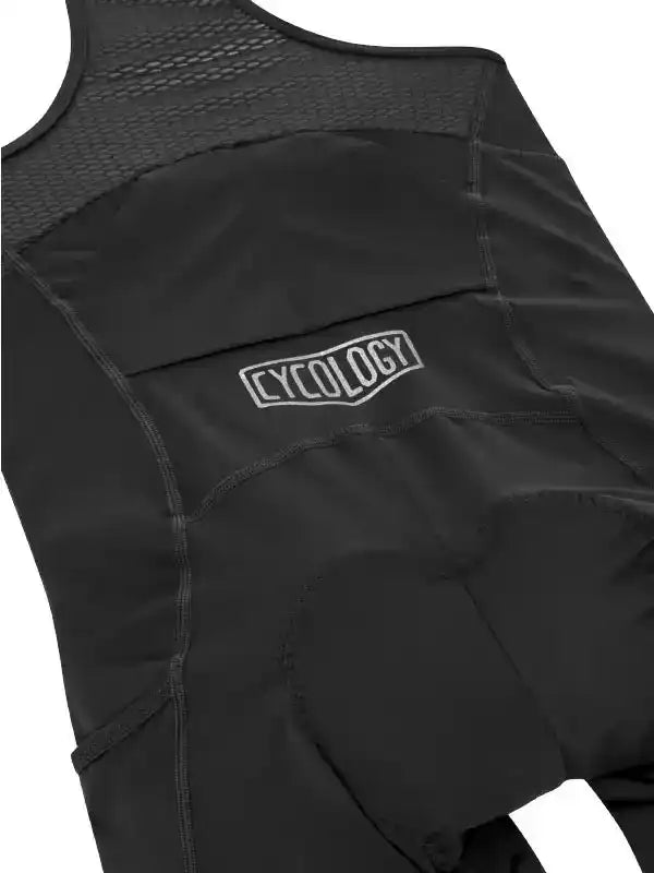 Black cycling bib shorts with padded seat and CYCOLOGY logo, designed for comfort and performance.