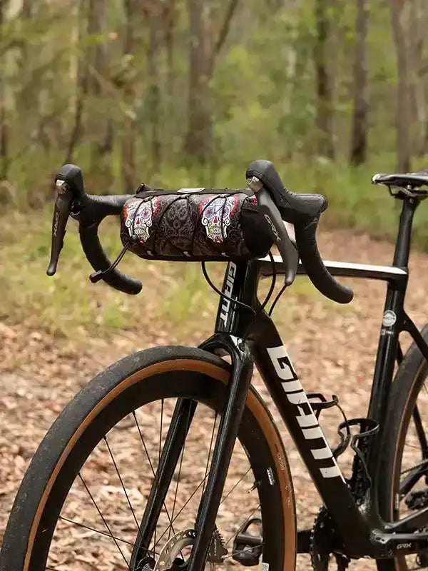 Cycling handlebar bag with sugar skull print on road bike in forest setting