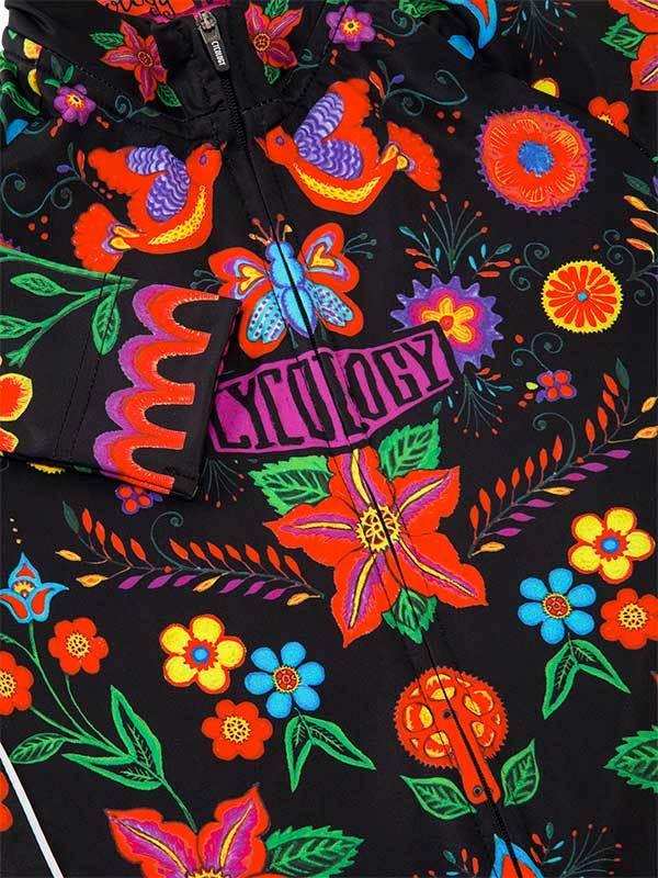 Vibrant floral and bird pattern cycling jersey with bold colors and 'CYCOLOGY' logo on black fabric.