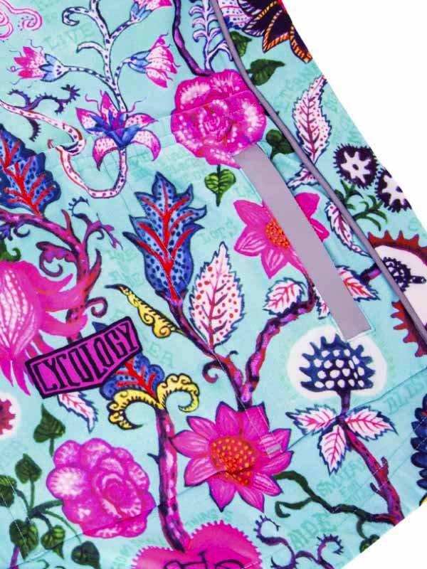 Vibrant floral cycling shorts with pink and blue botanical print, featuring a zippered pocket and Cycology logo.