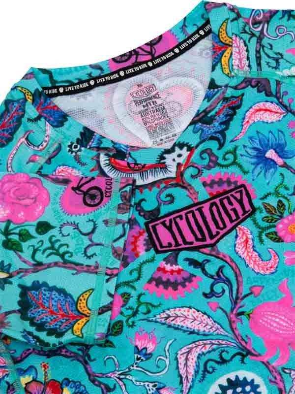 Vibrant turquoise cycling jersey with pink floral and bike graphics, featuring 'LIVE TO RIDE' collar detail