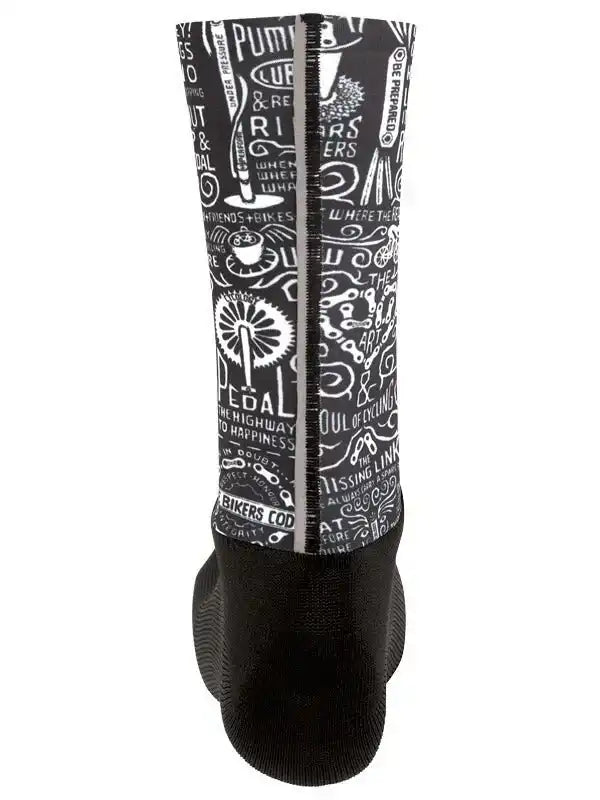 Black cycling shoe cover with white bike-themed graphics and text, featuring pedal and gear designs for road cyclists.