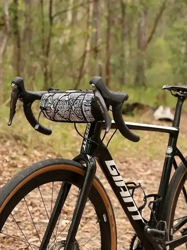 Cycling handlebar bag with doodle print on road bike in forest setting